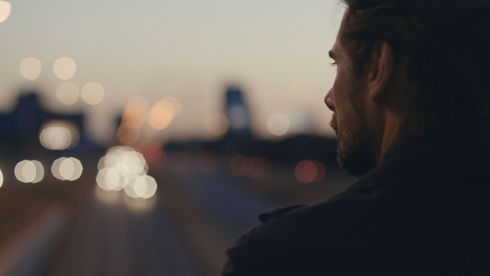 Man watching city lights. Still from Toyota Landcruiser.